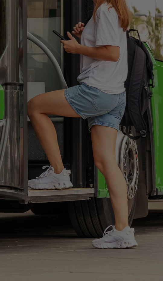 a woman standing on the door of a bus