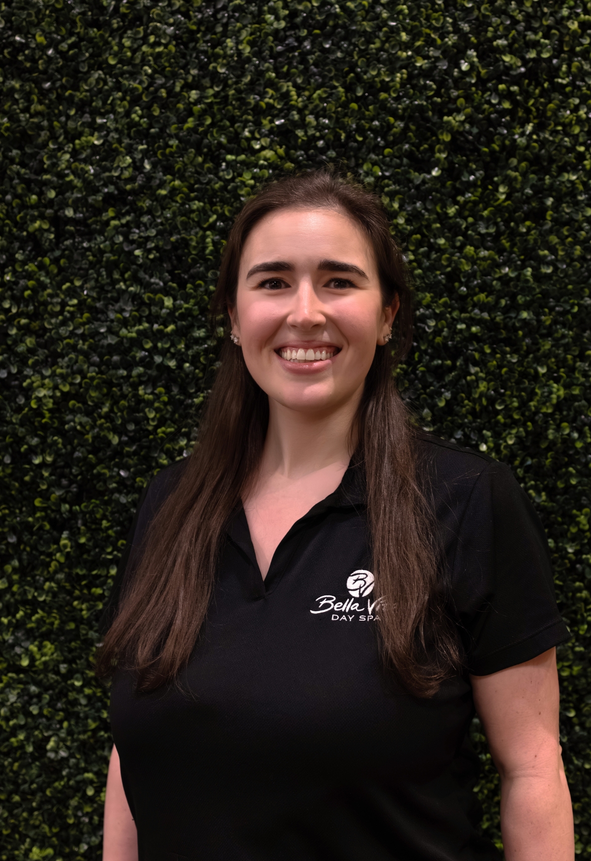 a woman smiling in front of a bush