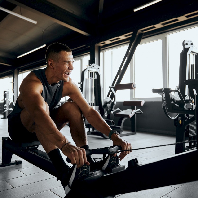 a man smiling while working out in a gym
