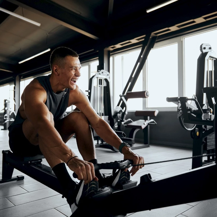 a man smiling while working out in a gym