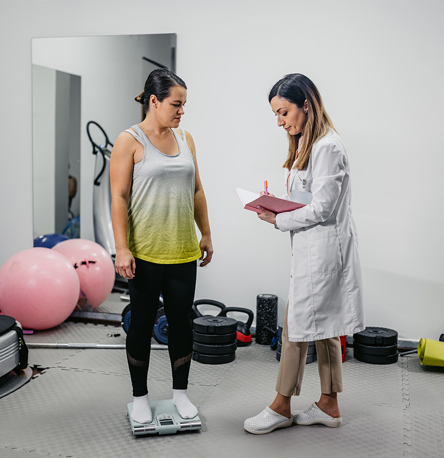 a woman standing on a scale with a doctor in the background