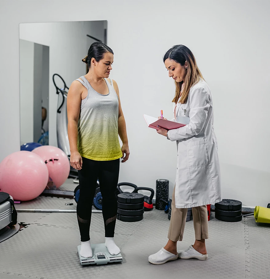 a woman standing on a scale with a doctor in the background
