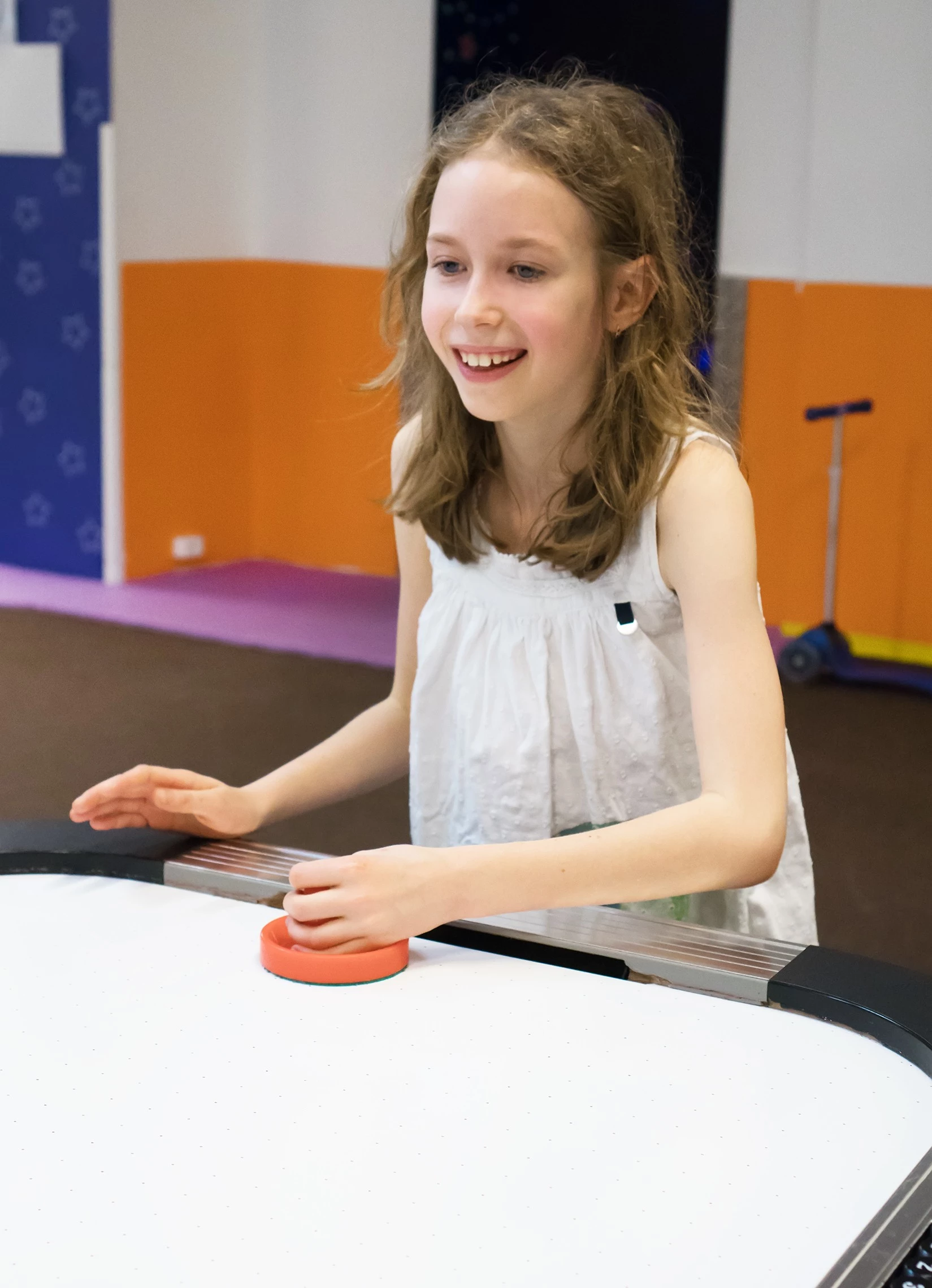 a girl playing air hockey