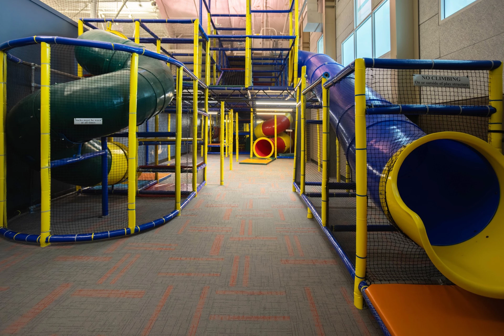 a large indoor play area with a tunnel and slide