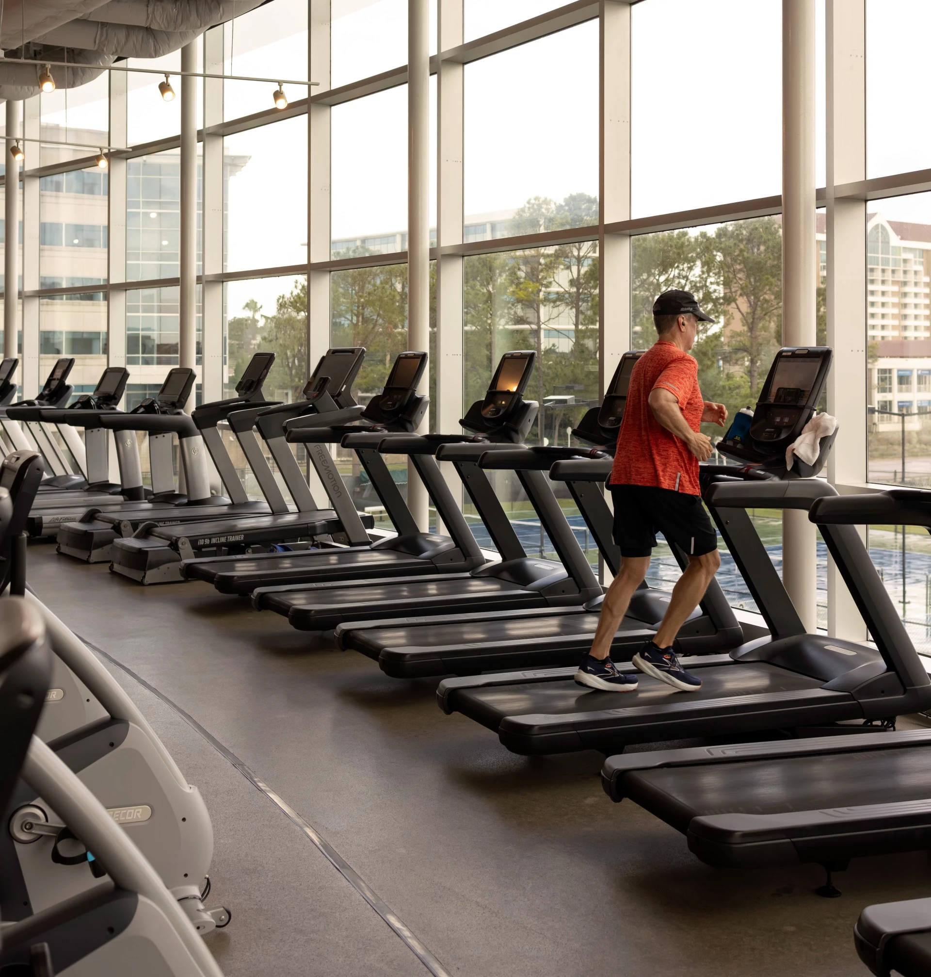 a man running on treadmills in a gym