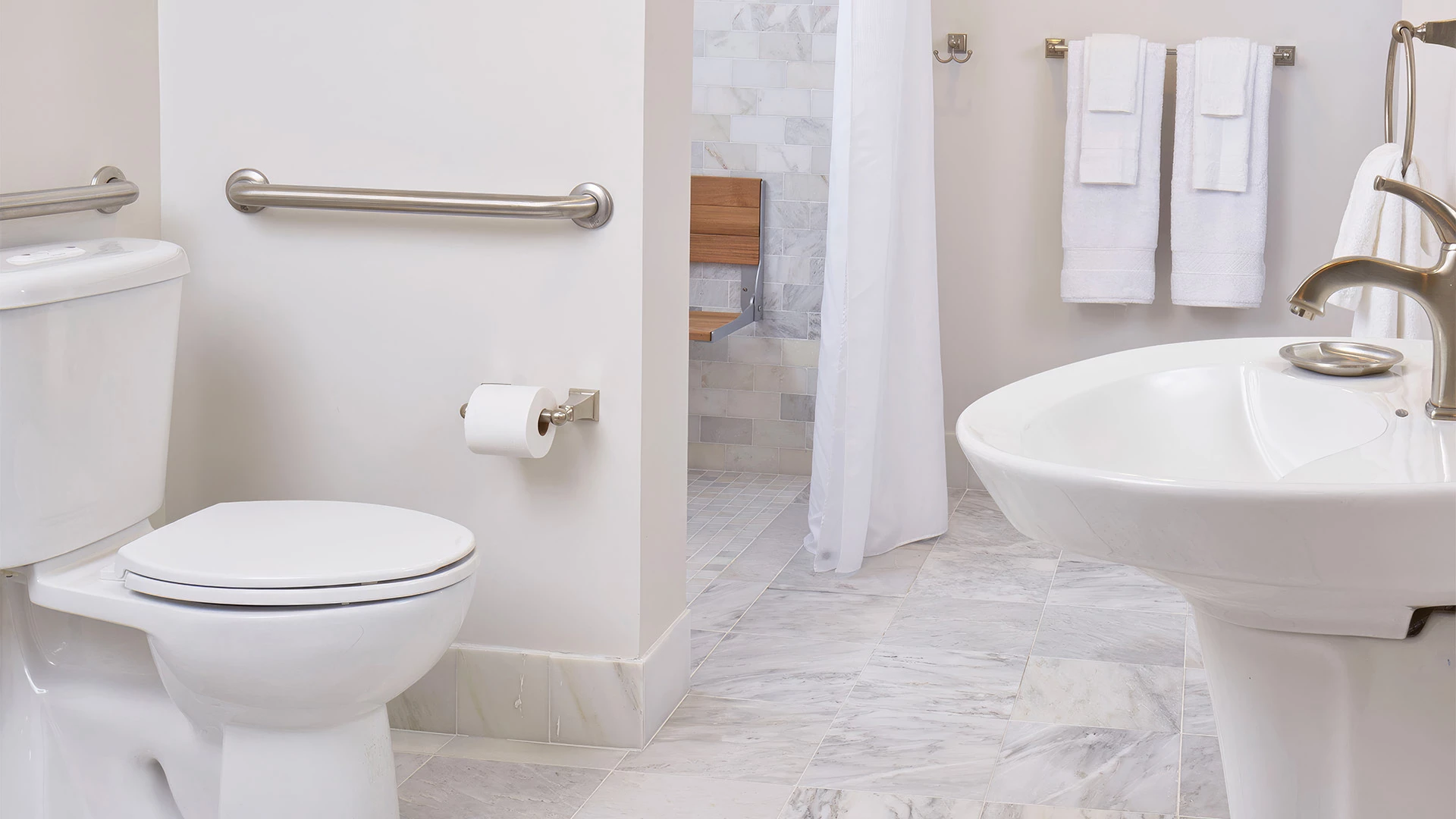 A clean bathroom with a toilet, sink, and shower curtain.