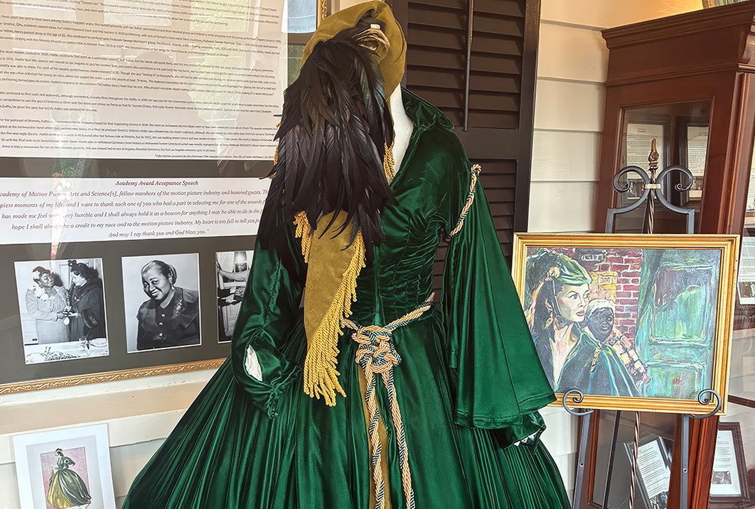 a mannequin wearing a green dress and a scarf