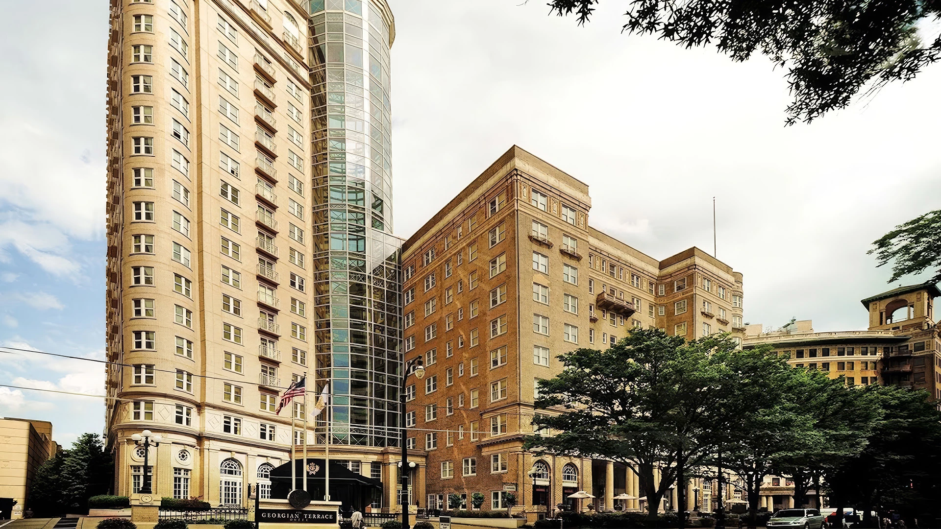 A large building with a glass tower and a flagpole in front of it.