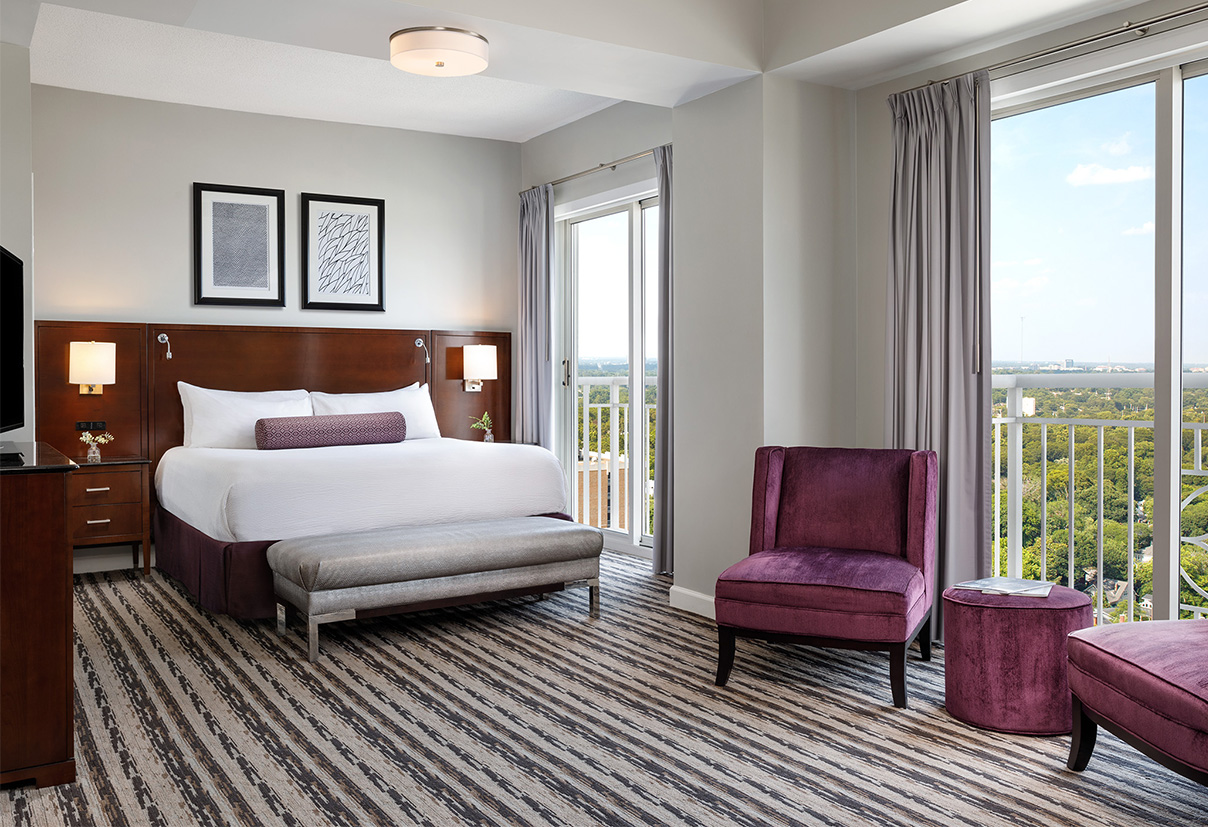 a bedroom with a bed and purple chairs