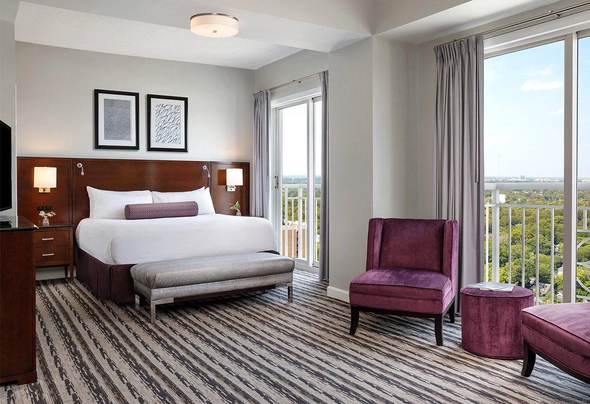 a bedroom with a bed and purple chairs