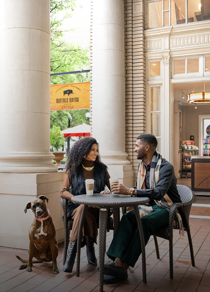 a man and woman sitting at a table with a dog