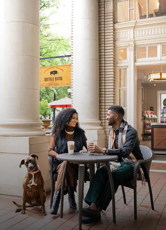 a man and woman sitting at a table with a dog