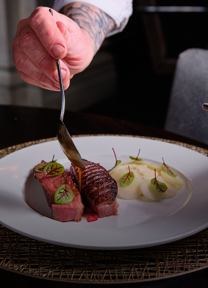 a person holding a fork over a plate of food