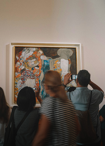 a group of people taking pictures of a painting