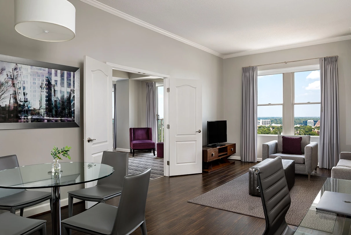a living room with a glass table and chairs