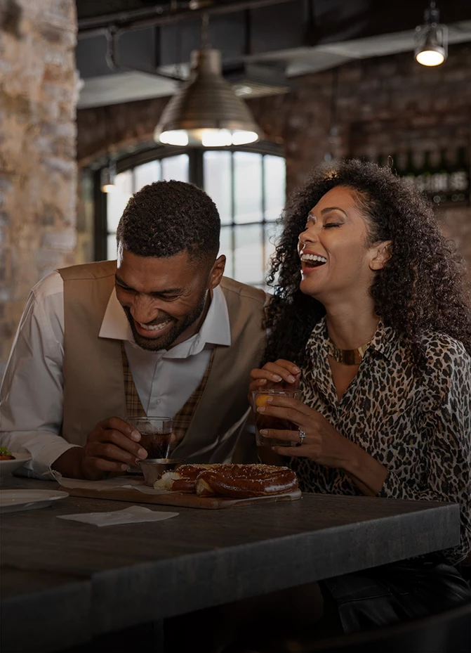 a man and woman laughing at a table