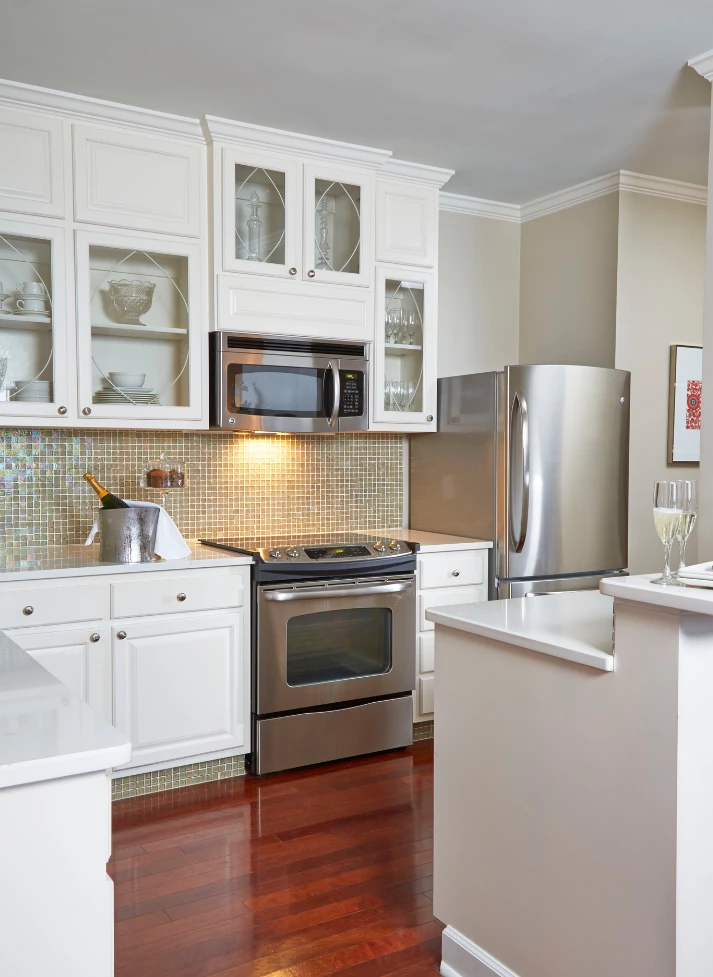 a kitchen with white cabinets and stainless steel appliances