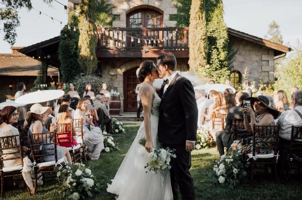 a man and woman kissing in front of a wedding ceremony