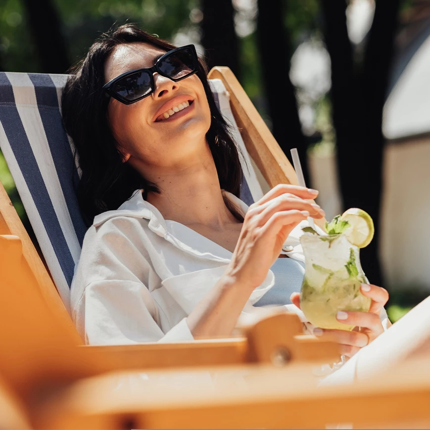 a woman sitting in a chair holding a drink