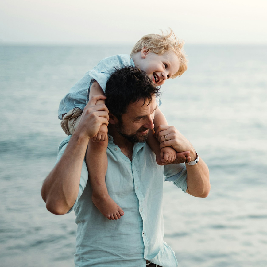 a man carrying a child on his shoulders