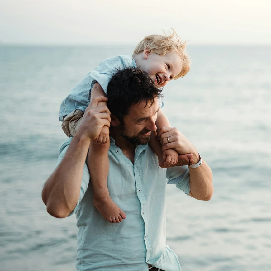 a man carrying a child on his shoulders