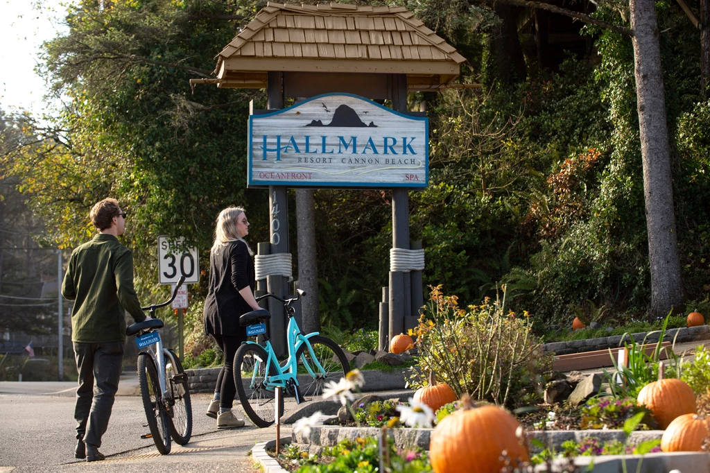 a couple of people riding bicycles in front of a sign
