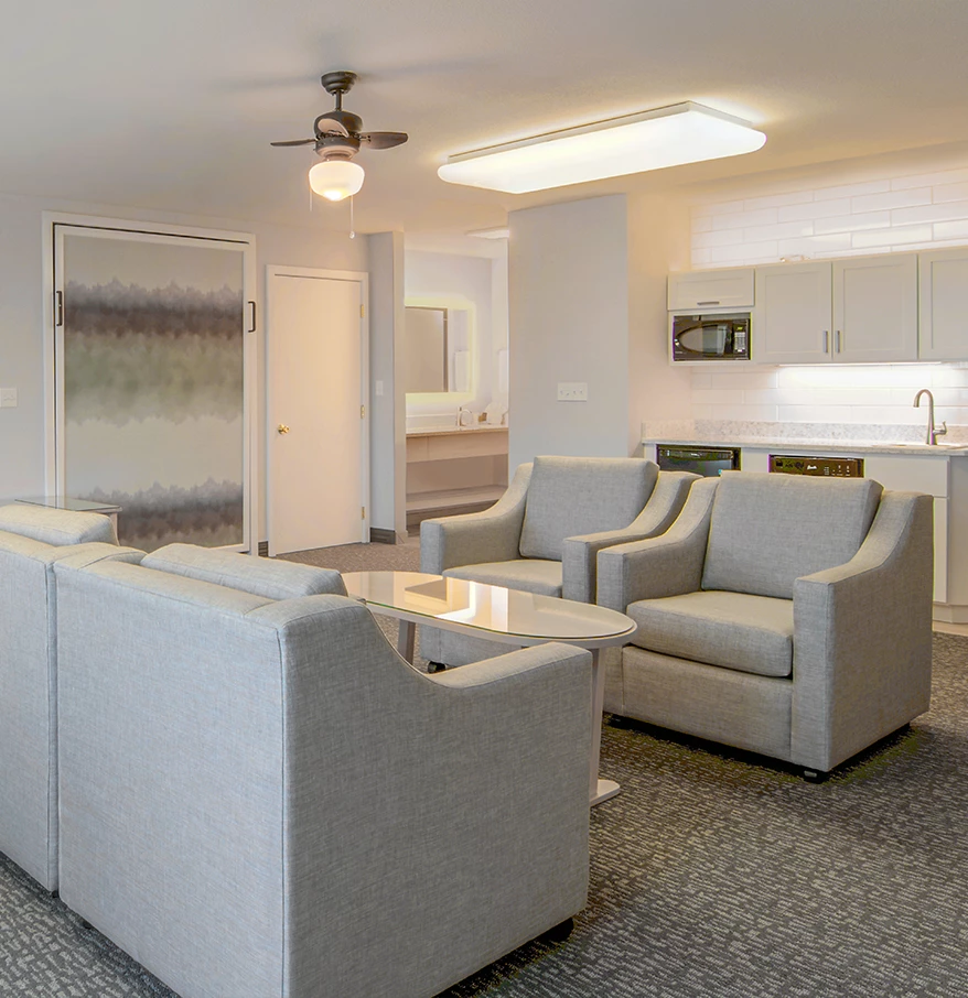 a living room with couches and a kitchen