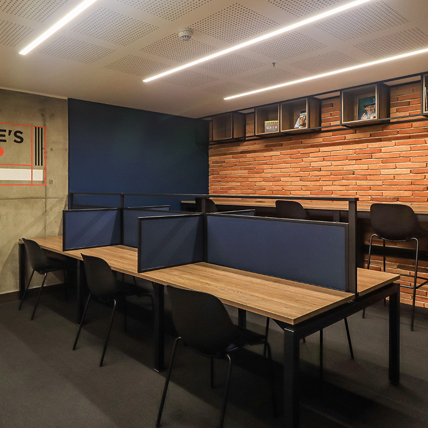 a room with a desk and chairs