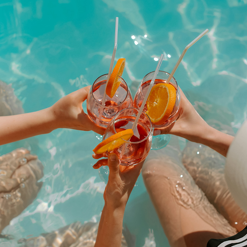 a group of people holding drinks in a pool