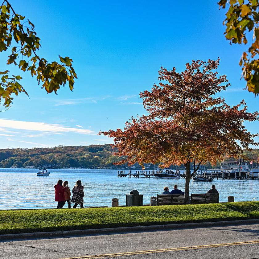 a group of people walking on a path by a body of water