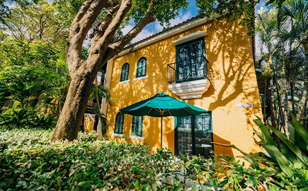 a yellow building with a green umbrella