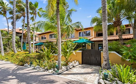 a building with palm trees and a gate