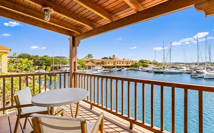 a table and chairs on a deck overlooking a body of water