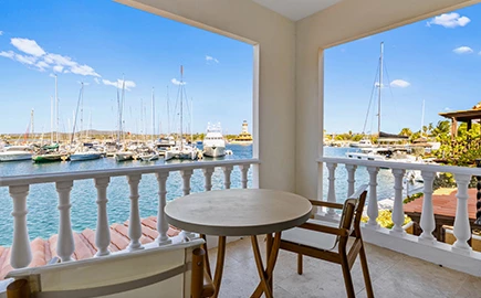 a table and chairs on a balcony overlooking a body of water