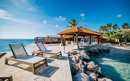 a beach with chairs and a building by the water
