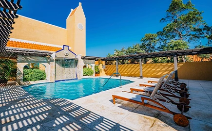 a pool with chairs and a building