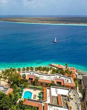a body of water with buildings and a sailboat