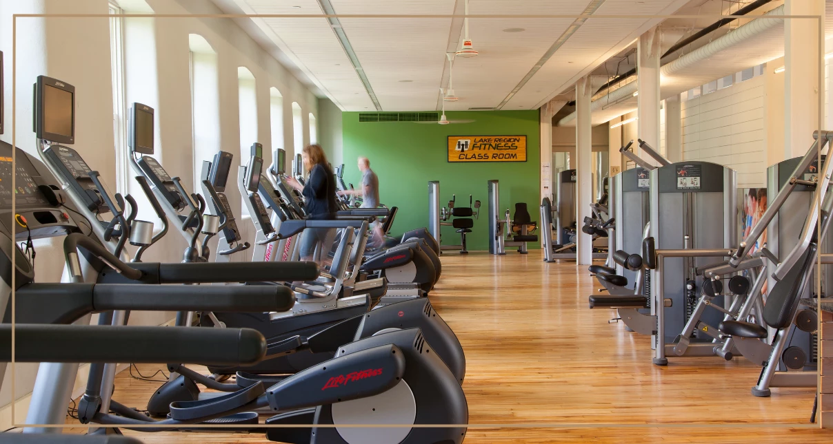 a room with exercise equipment and people in the background
