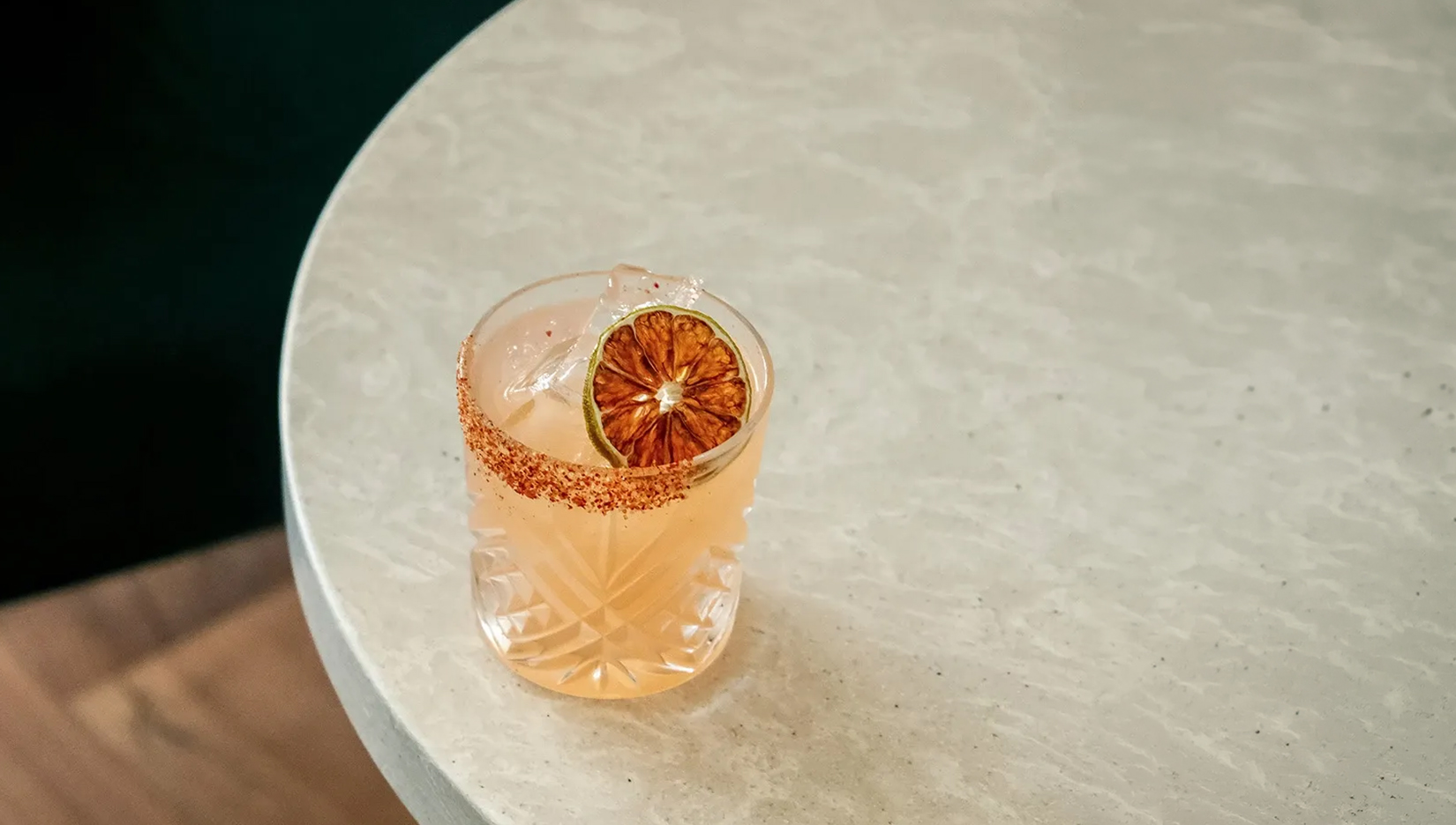 a glass with a drink and a slice of orange on top