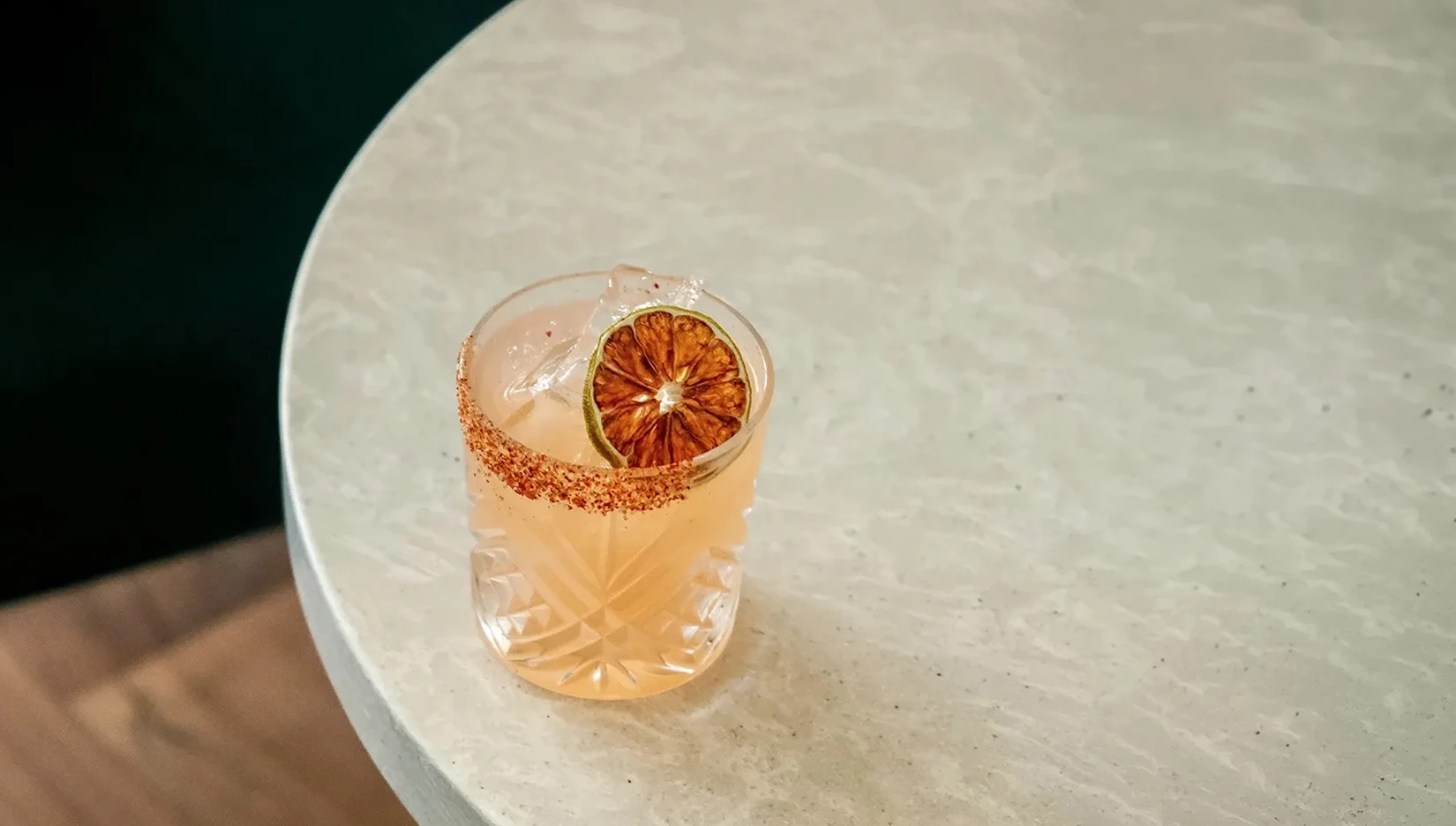 a glass with a drink and a slice of orange on top