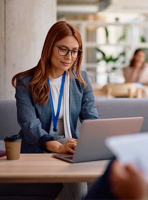 a woman sitting at a table using a laptop
