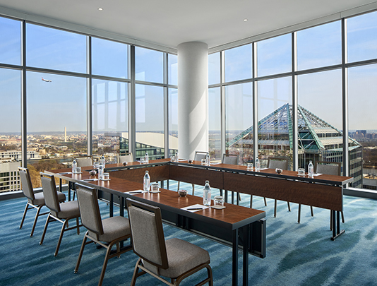 a room with a large window and tables and chairs