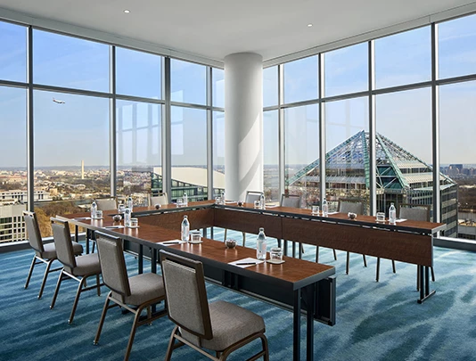 a room with a large window and tables and chairs