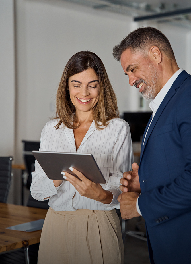 a man and woman looking at a tablet