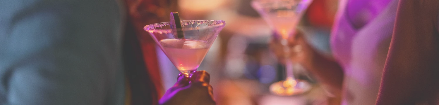 a person holding a glass of liquid