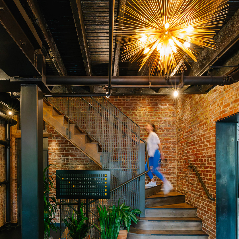 a woman walking up a staircase in a brick building