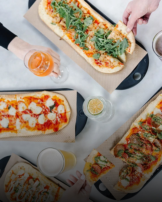 a table with pizzas and drinks