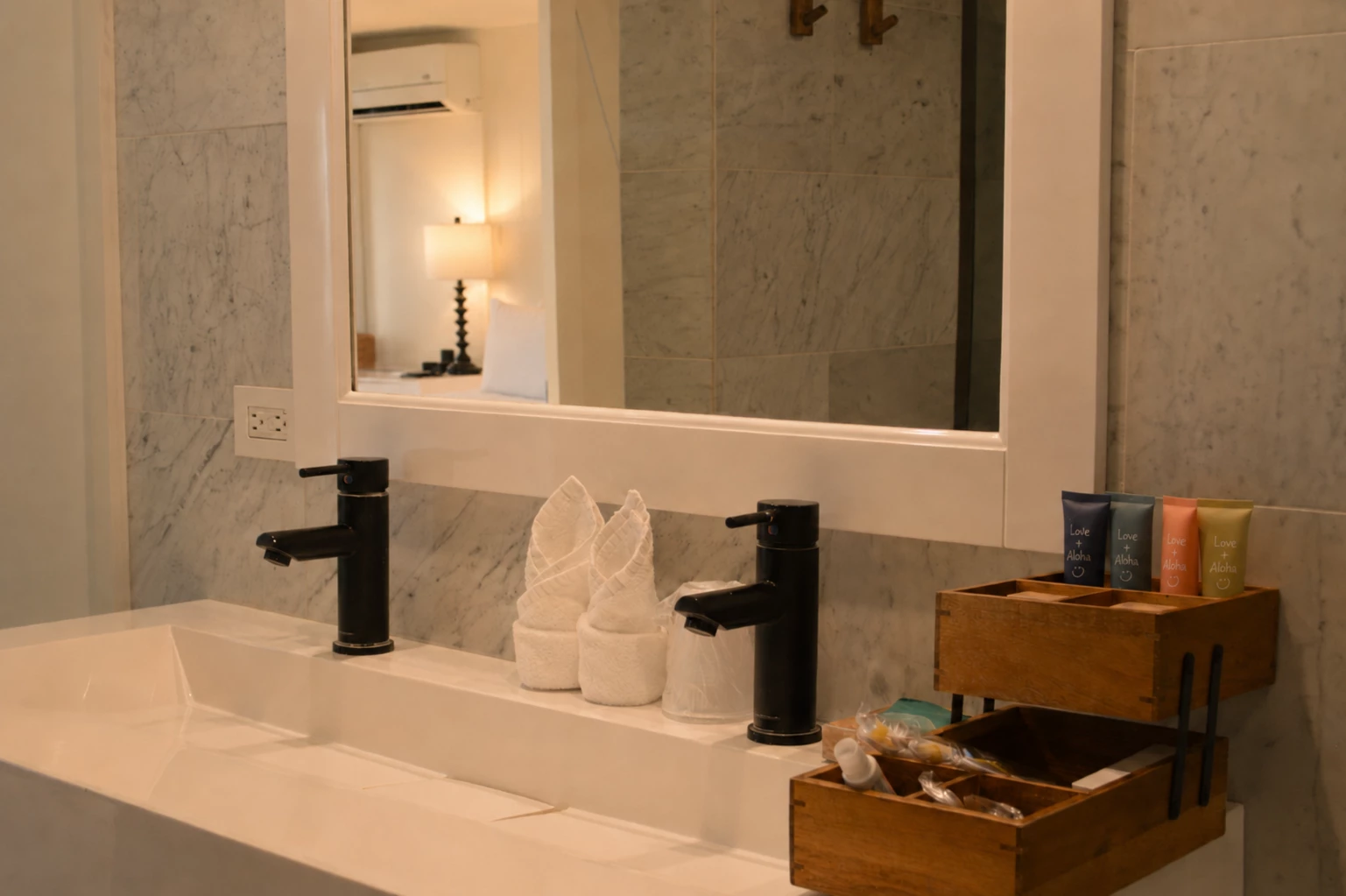 A clean and modern bathroom vanity with a large mirror, double sink, and wooden organizer with toiletries.