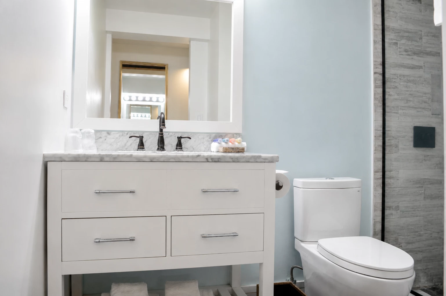 A clean and modern bathroom with a double vanity, toilet, and shower.