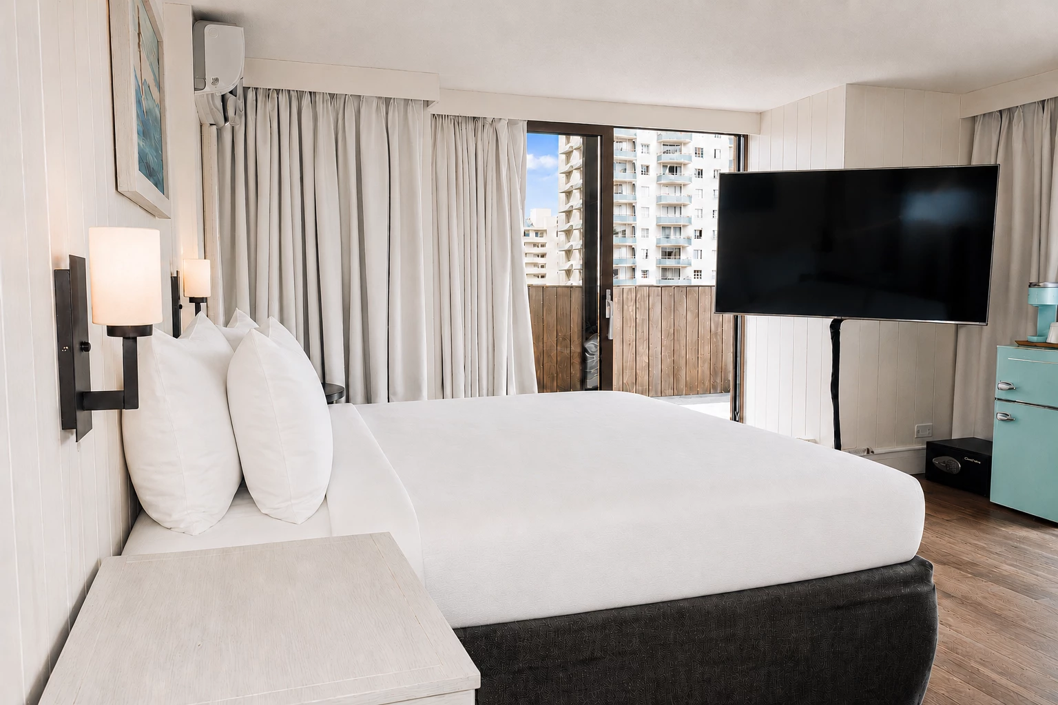 A hotel room with a large bed, TV, and balcony